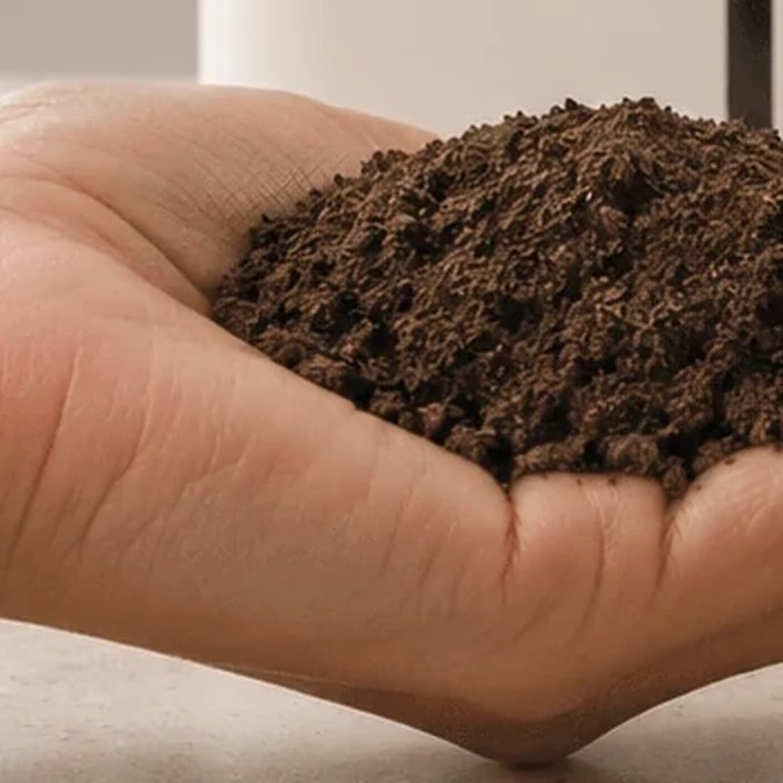 Finished compost from an EcoSense Pro going onto plants in Silver, the dark graphite finish